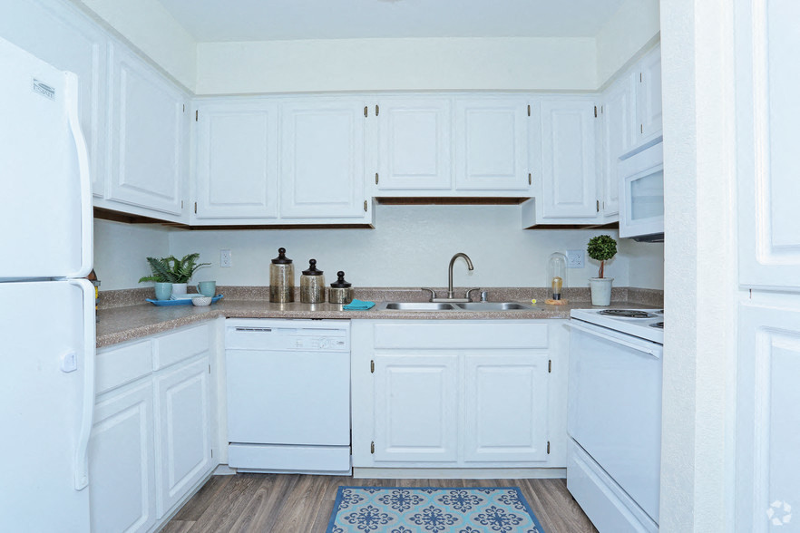 a white kitchen with white cabinets and a sink