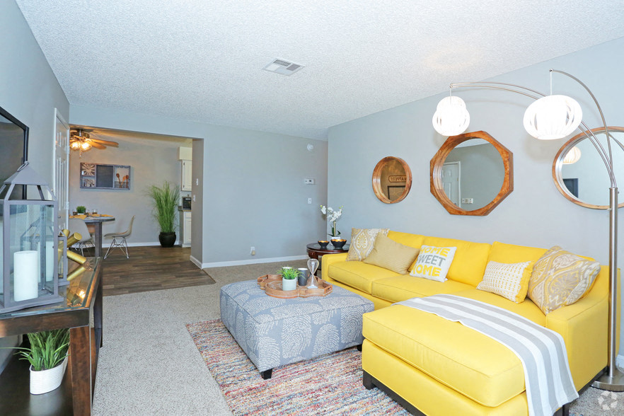 a living room with a yellow couch and a table