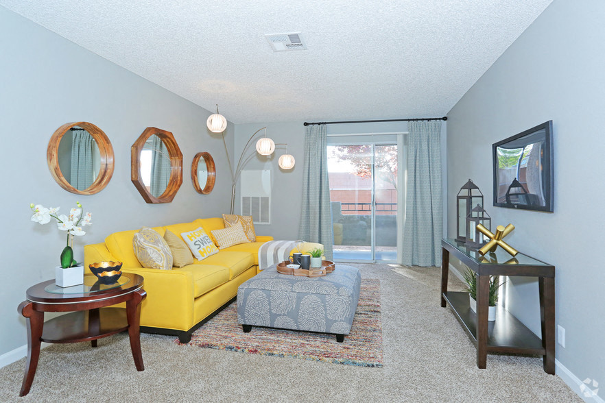 a living room with a yellow couch and a sliding glass door