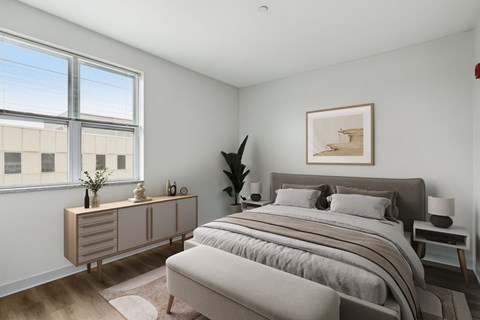 A bedroom with a large bed and a window overlooking a building.