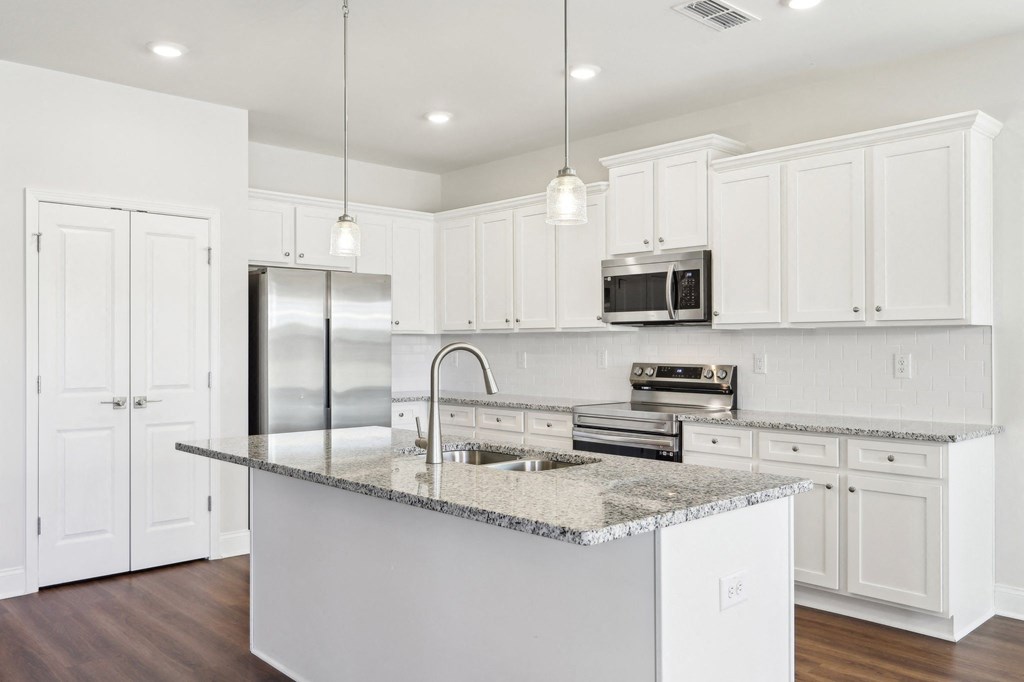 Sleek kitchen with white cabinetry and granite countertops.