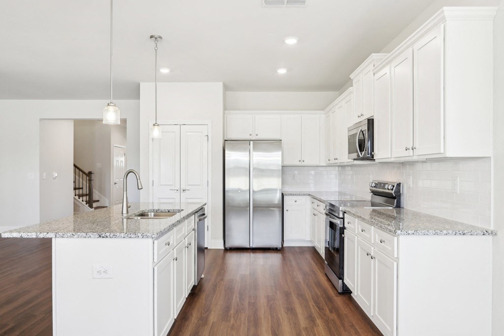Modern kitchen featuring white cabinets and granite countertops.