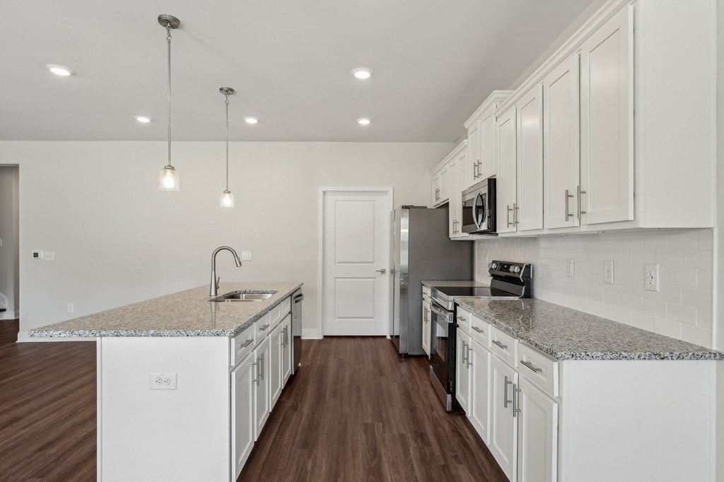 Modern kitchen featuring white cabinets and granite countertops.