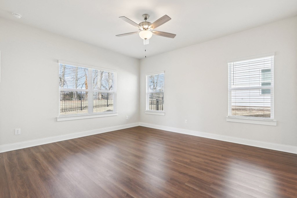 Bedroom with wood floors and a ceiling fan.
