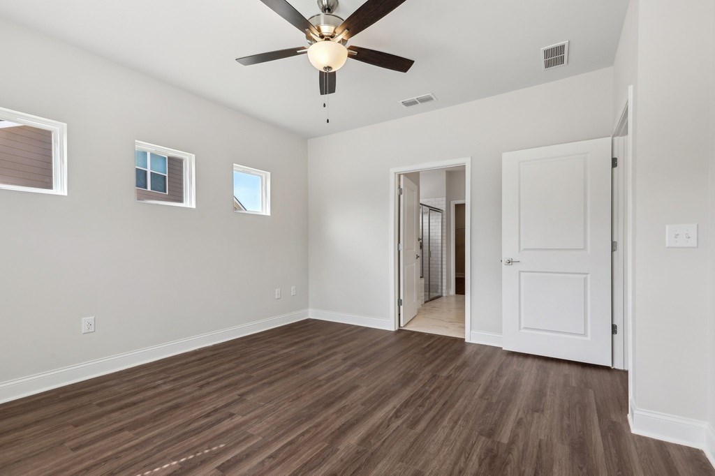 Bedroom with wood floors and a ceiling fan.