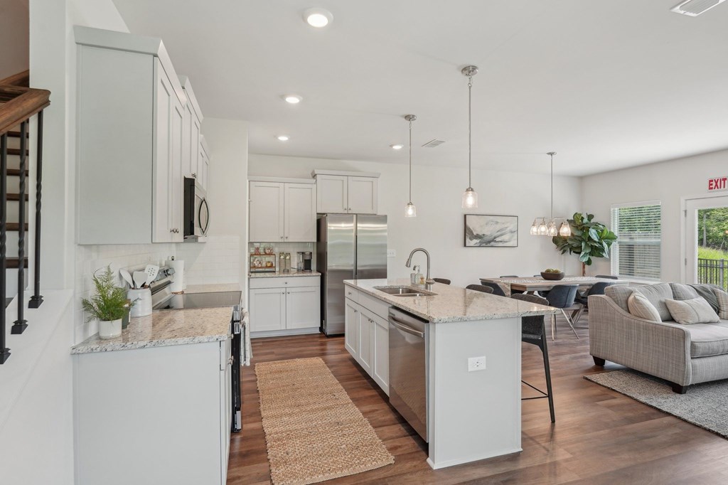 A modern kitchen showcasing a granite countertop island with bar seating and premium stainless steel appliances.