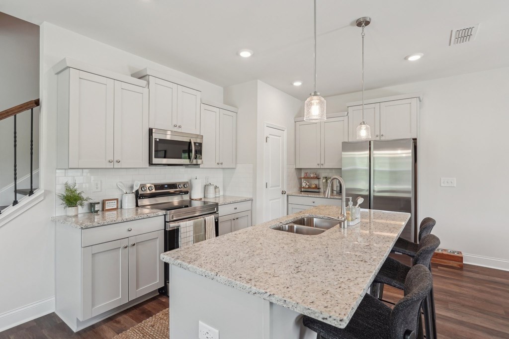 Kitchen featuring a sleek granite countertop and a convenient sink.