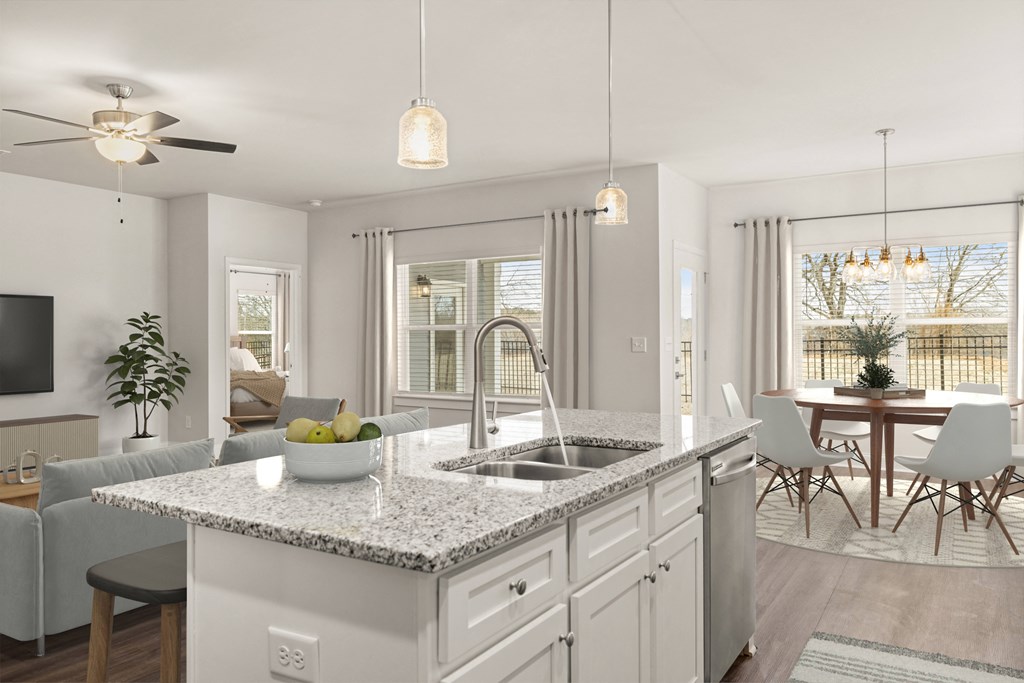 Living room with large windows that let in a ton of natural light. Looking into the kitchen and the back patio door.
