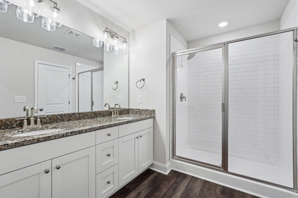 Primary bathroom with double vanity, walk-in shower and walk-in closet.