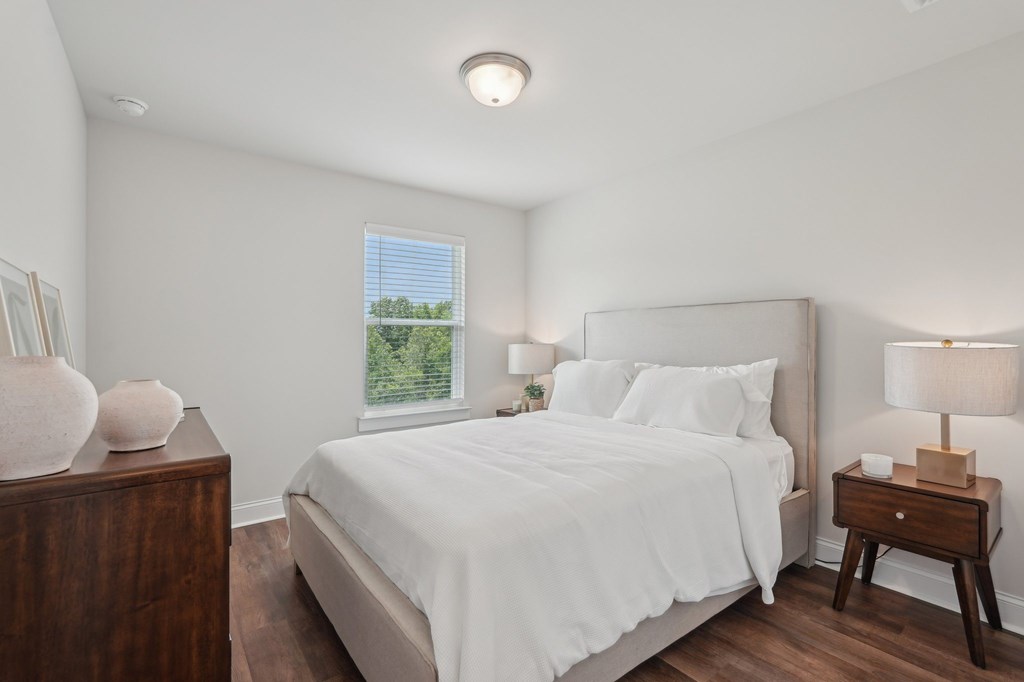 Secondary bedroom with a queen-size bed and bright natural light streaming through a large window.