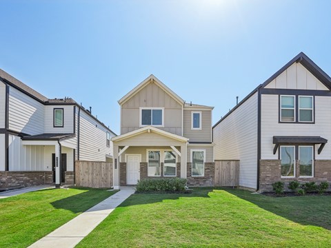 a row of houses with a sidewalk and lawn