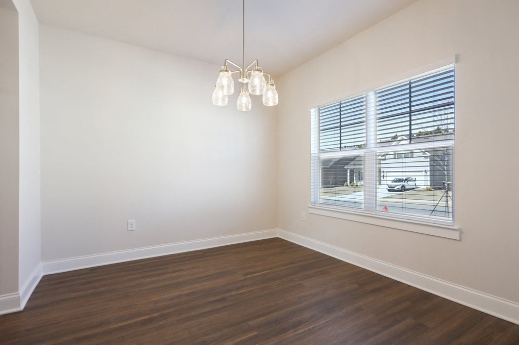 Bright room with wood floors and a large window, perfect for a kitchen table.