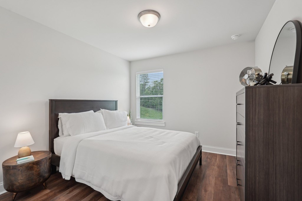 Third bedroom with a queen-size bed and abundant natural light streaming through the window.