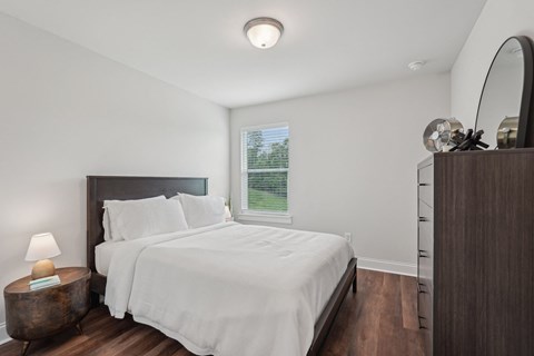 Third bedroom with a queen-size bed and abundant natural light streaming through the window.