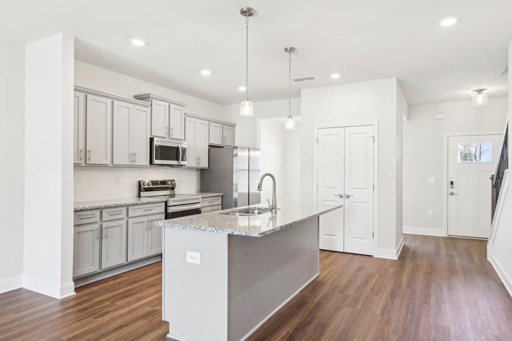 Sleek kitchen with white cabinetry and granite countertops.