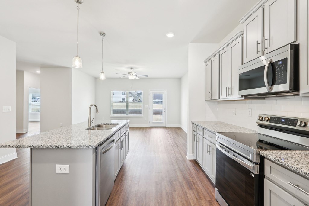 Sleek modern kitchen with white cabinetry and granite countertops.