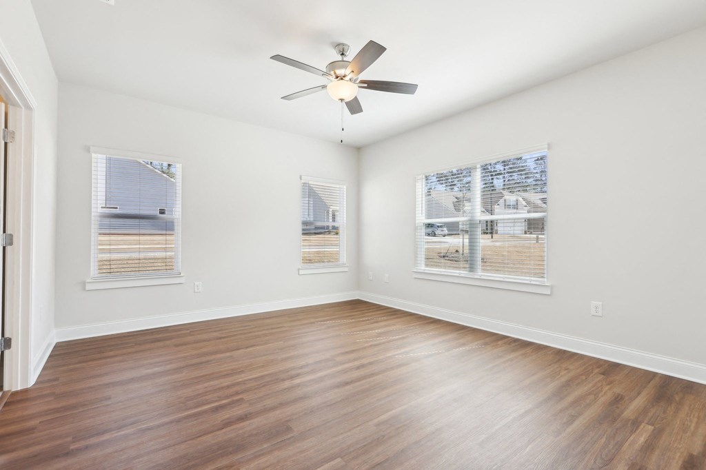 Bedroom with wood floors and a ceiling fan.