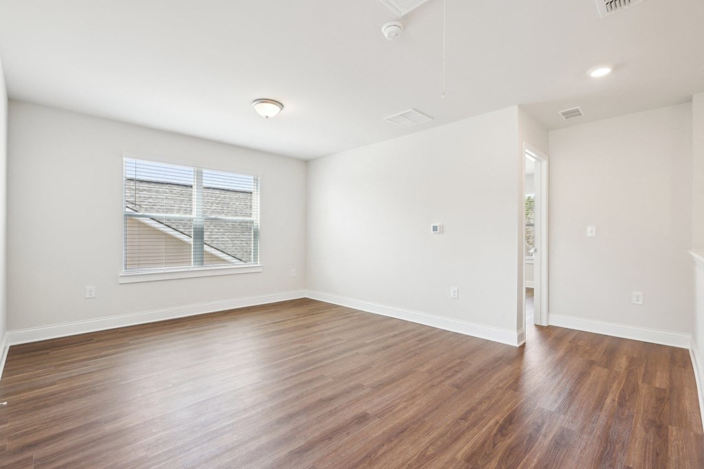 Cozy bedroom with wood floors and a ceiling fan.