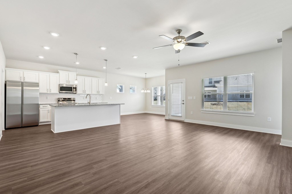 Spacious kitchen equipped with a refrigerator, sink, and ceiling fan.