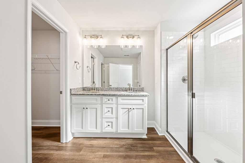 Primary bathroom with double vanity, walk-in shower and walk-in closet.