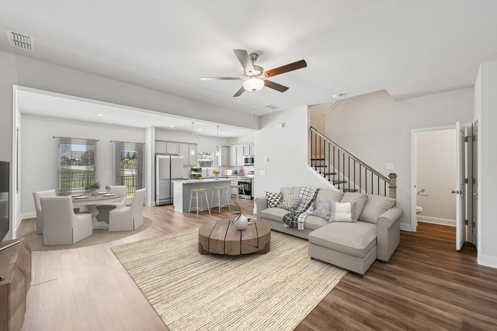 View of the living room area featuring an open staircase and refined dining space.