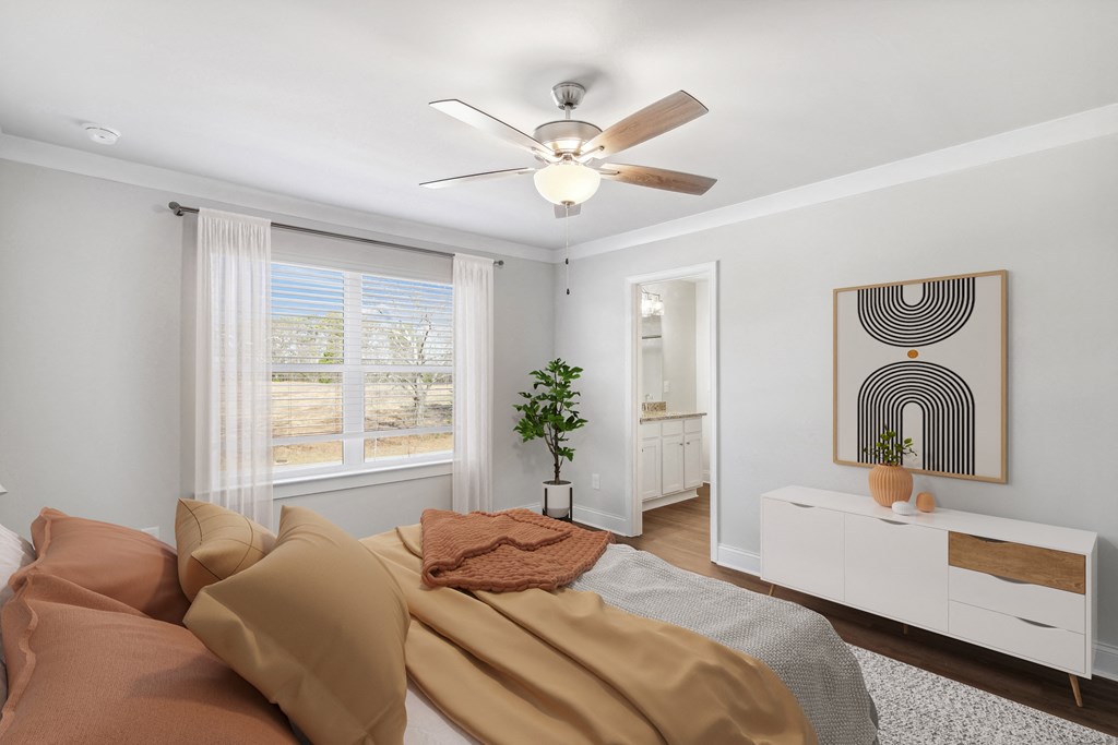 Another view of the spacious primary suite showcasing a grand bed and modern ceiling fan.