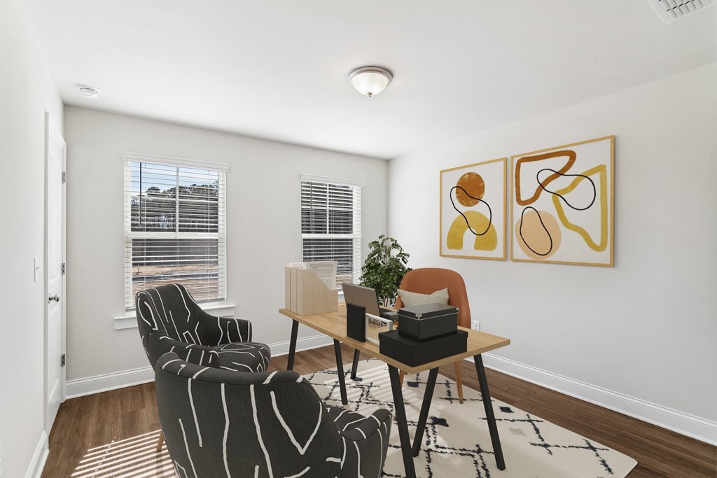 a living room with two chairs and a table and two windows