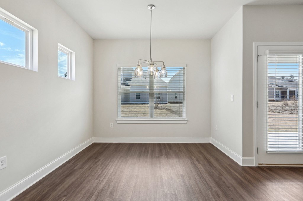 Bright room with wood floors and a large window, perfect for a kitchen table.