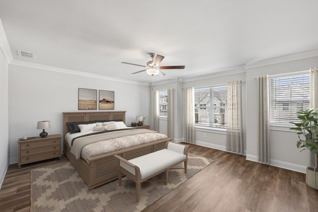 The elegant primary bedroom featuring a plush bed, stylish nightstand, and accent chair.