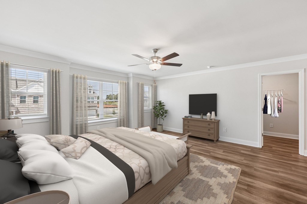 Another view of the spacious primary suite showcasing a grand bed and modern ceiling fan.