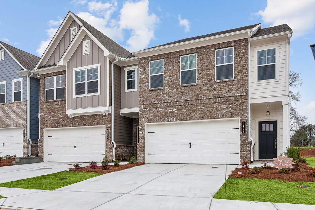 a brick house with two garage doors in front of it