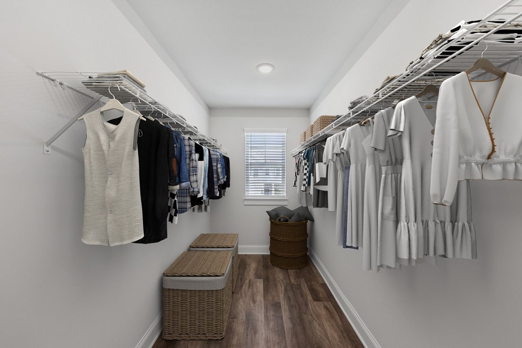 The luxury primary suite with a full walk in closet featuring custom racks and a stylish bench.