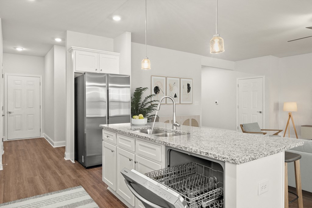 Living room with large windows that let in a ton of natural light looking into the kitchen.
