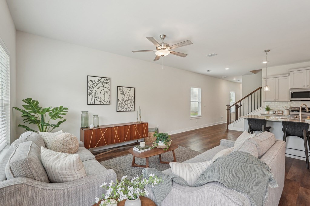 View of the living room area featuring an open staircase and refined dining space.