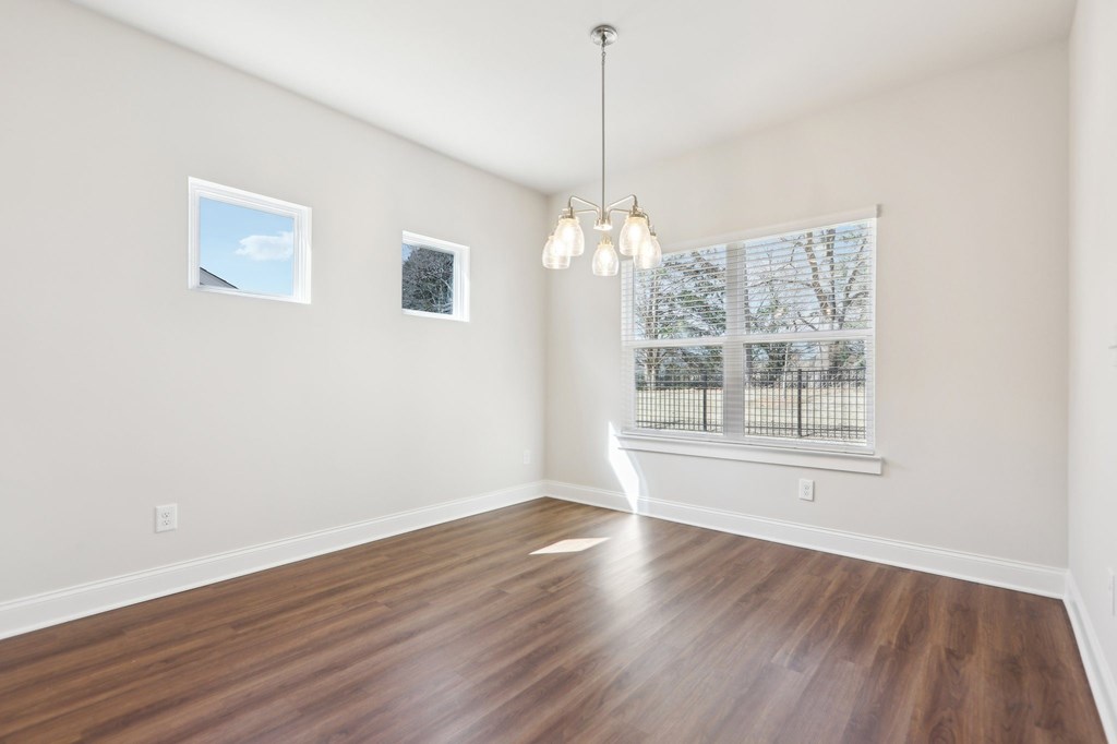 Bright room with wood floors and a large window, perfect for a kitchen table.