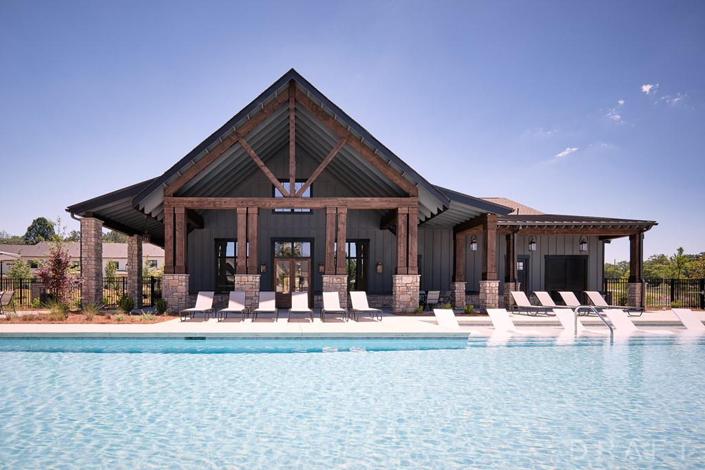 a house with a pool and lounge chairs