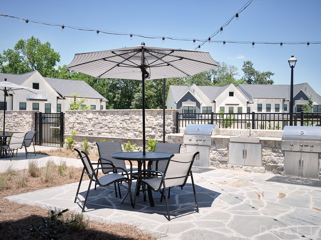 a patio with a table and chairs under an umbrella
