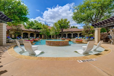 a resort style pool with lounge chairs and a fire pit