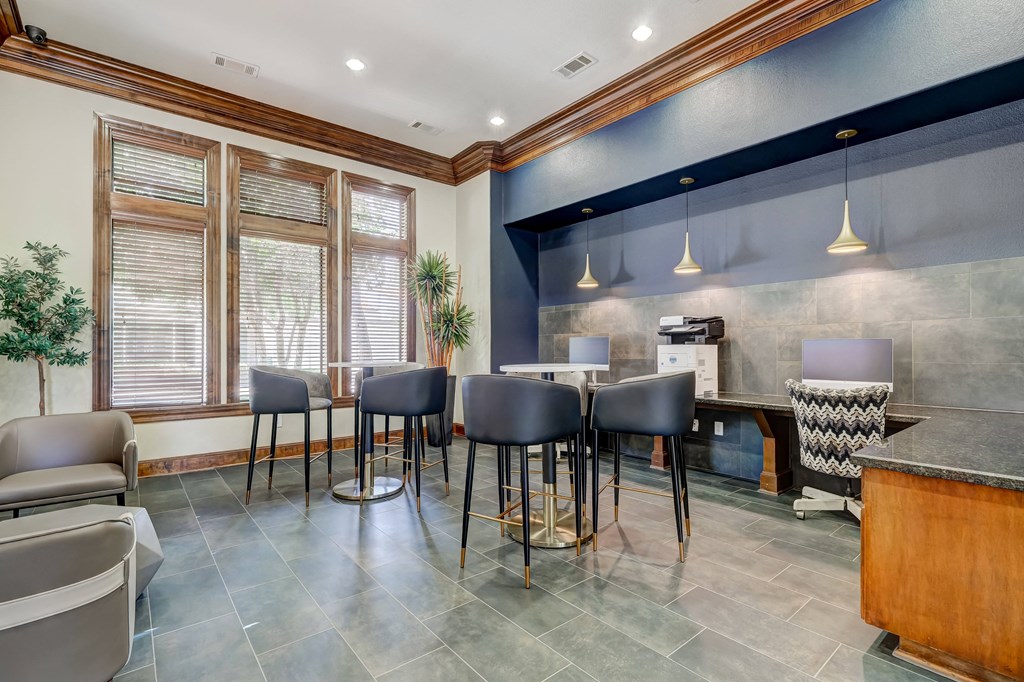 a common area with a table and chairs and a kitchenette in the background