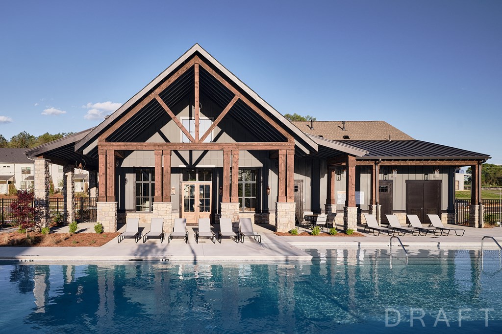 a house with a pool and chairs in front of it