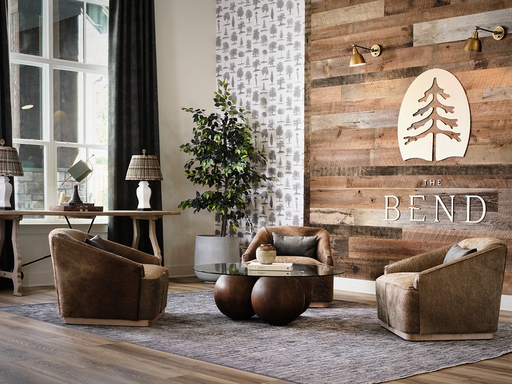a living room with two chairs and a table and the bend logo on the wall