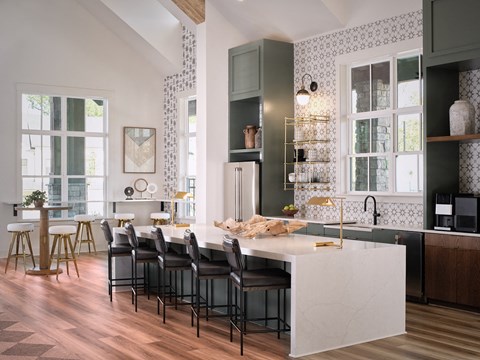 Kitchenette inside the clubhouse with bar seating, mini fridge and sink.