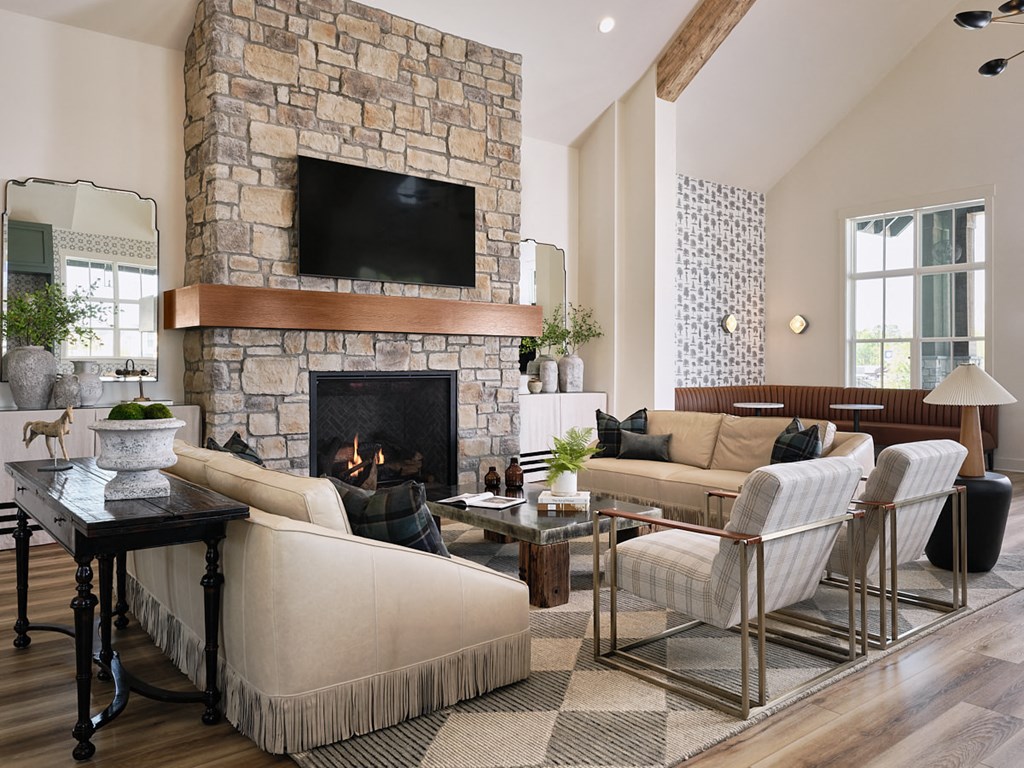 a living room with a stone fireplace and furniture