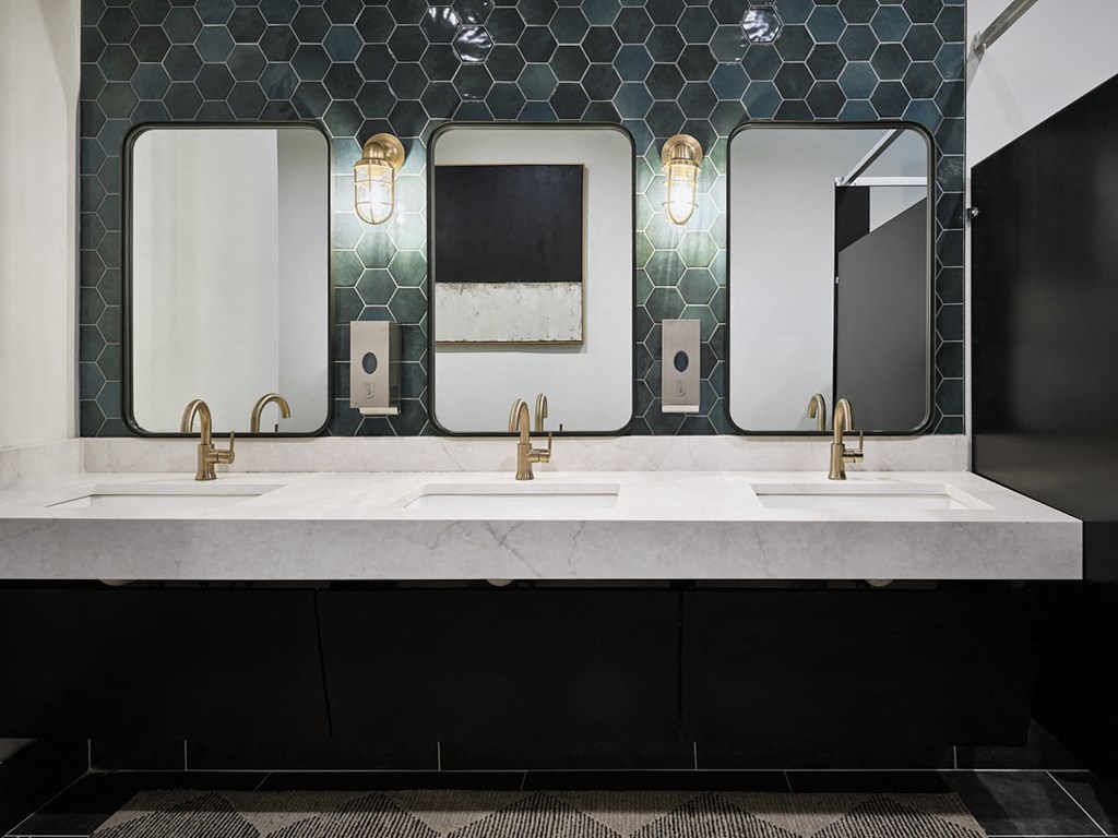 a bathroom with three sinks and three mirrors