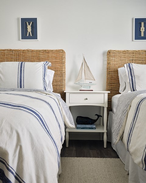 Charming third bedroom featuring two twin beds and a nightstand adorned with a sailboat accent.