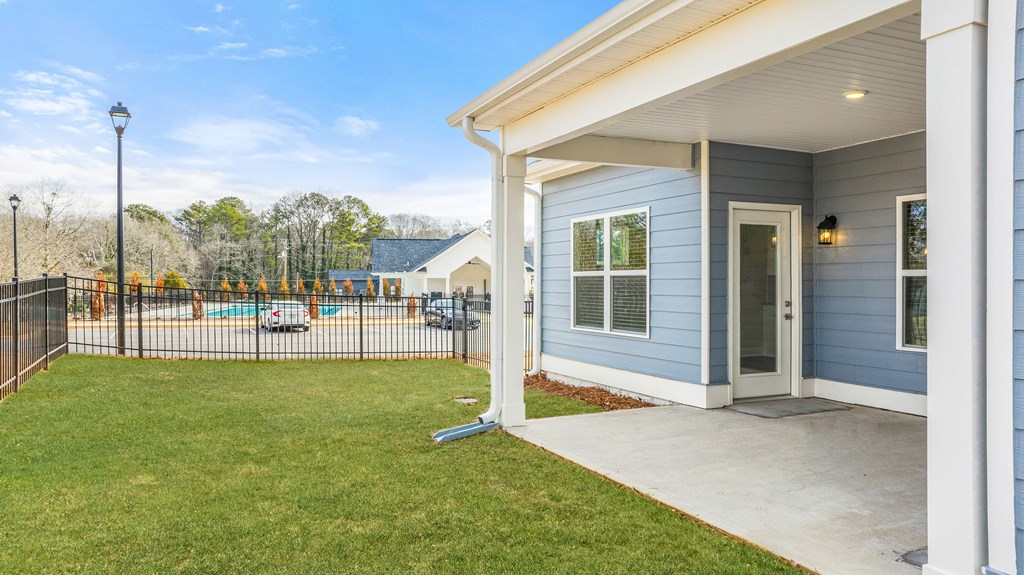 the entrance to a house with a yard and a fence