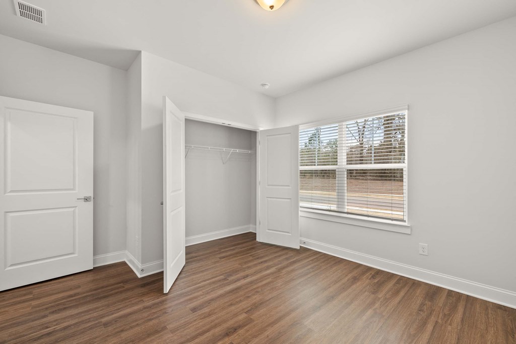 a room with white walls and a wooden floor and a glass shower
