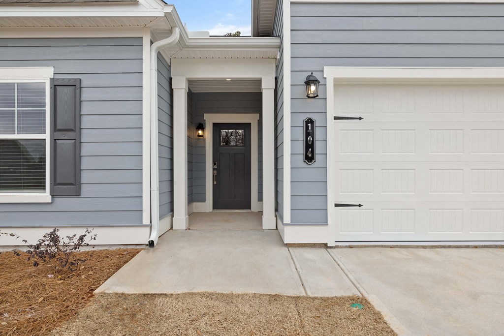 the front entrance to a blue house with a white garage door