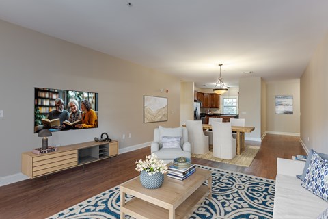 A living room with a white couch and a wooden coffee table.