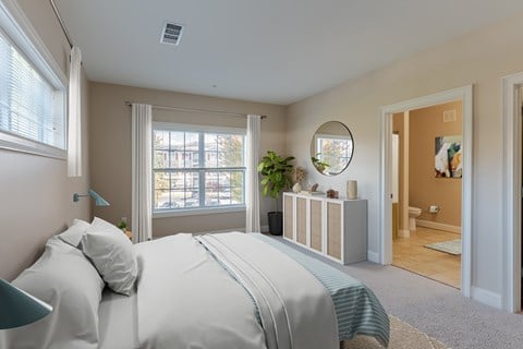 A bedroom with a large bed and a mirror on the wall.